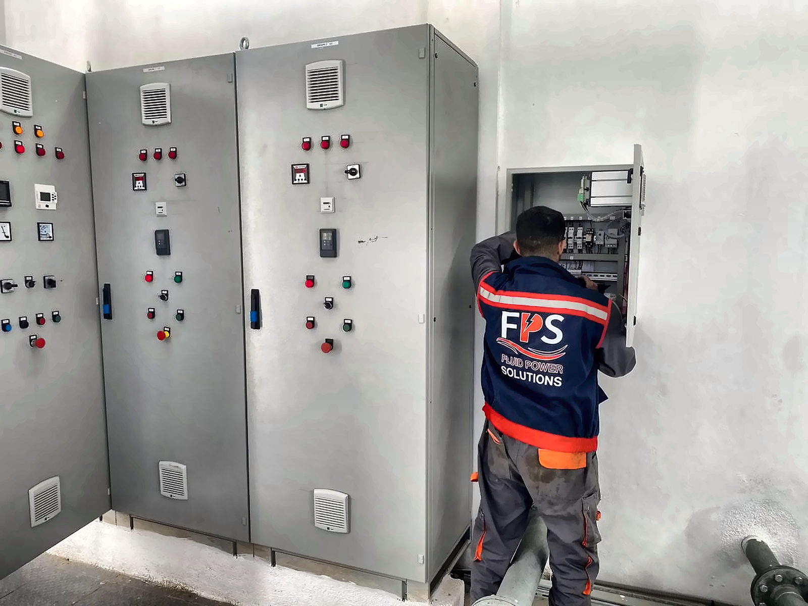 Technicien FPS raccordant un coffret électrique en station de pompage
