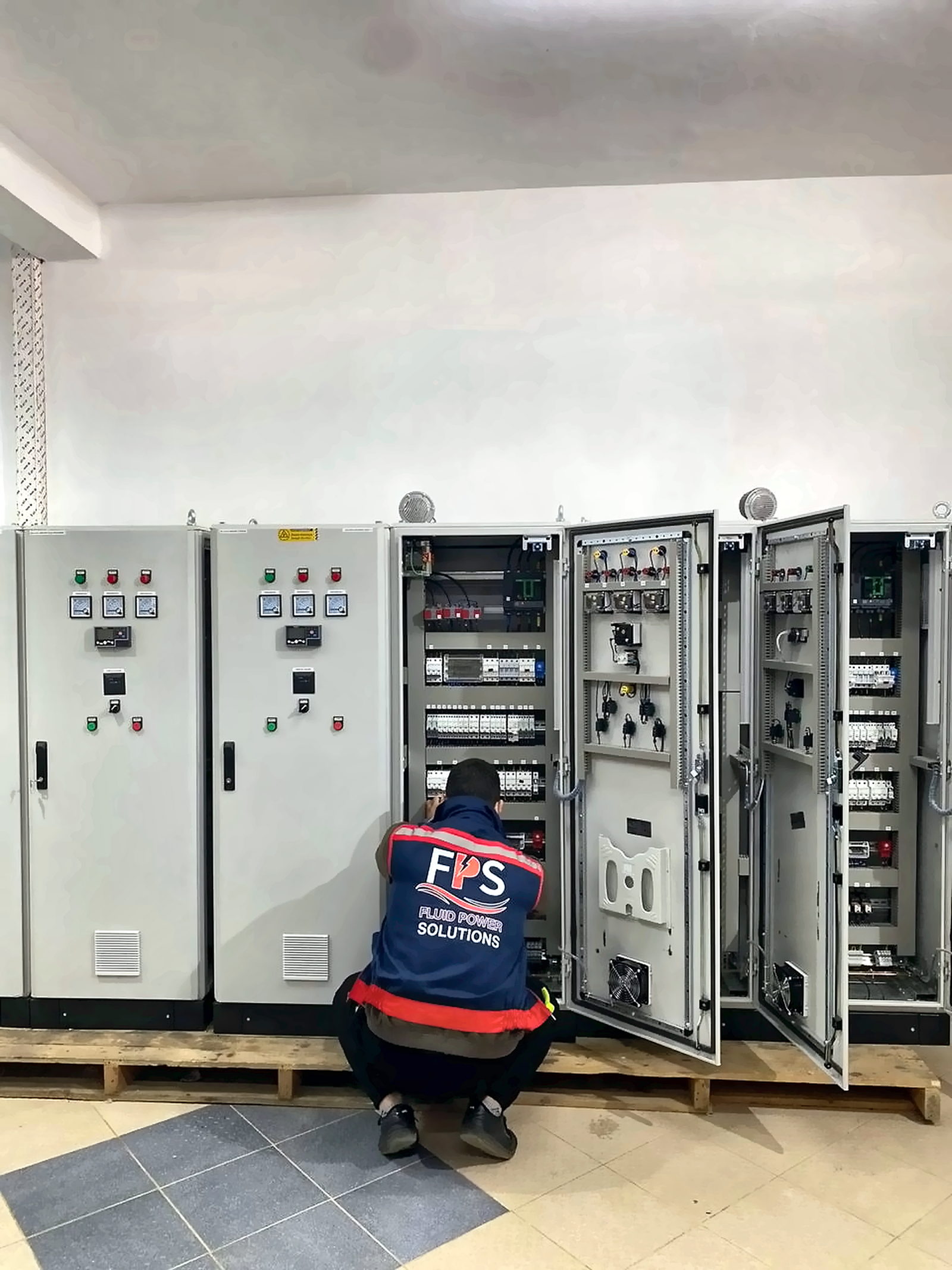 Technicien FPS effectuant les essais d'une armoire de commande avant livraison